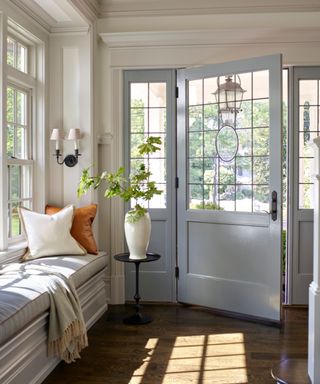light and bright entryway with a pale blue front door and bench seat