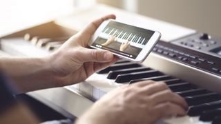 Man playing keyboards using a piano leaning app