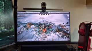 A picture of the Acer Predator X32QFS gaming monitor next to an LG productivity screen and a Volcanic Red PS5 Slim