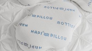 The Hapi Pillow in white photographed on white bed sheets