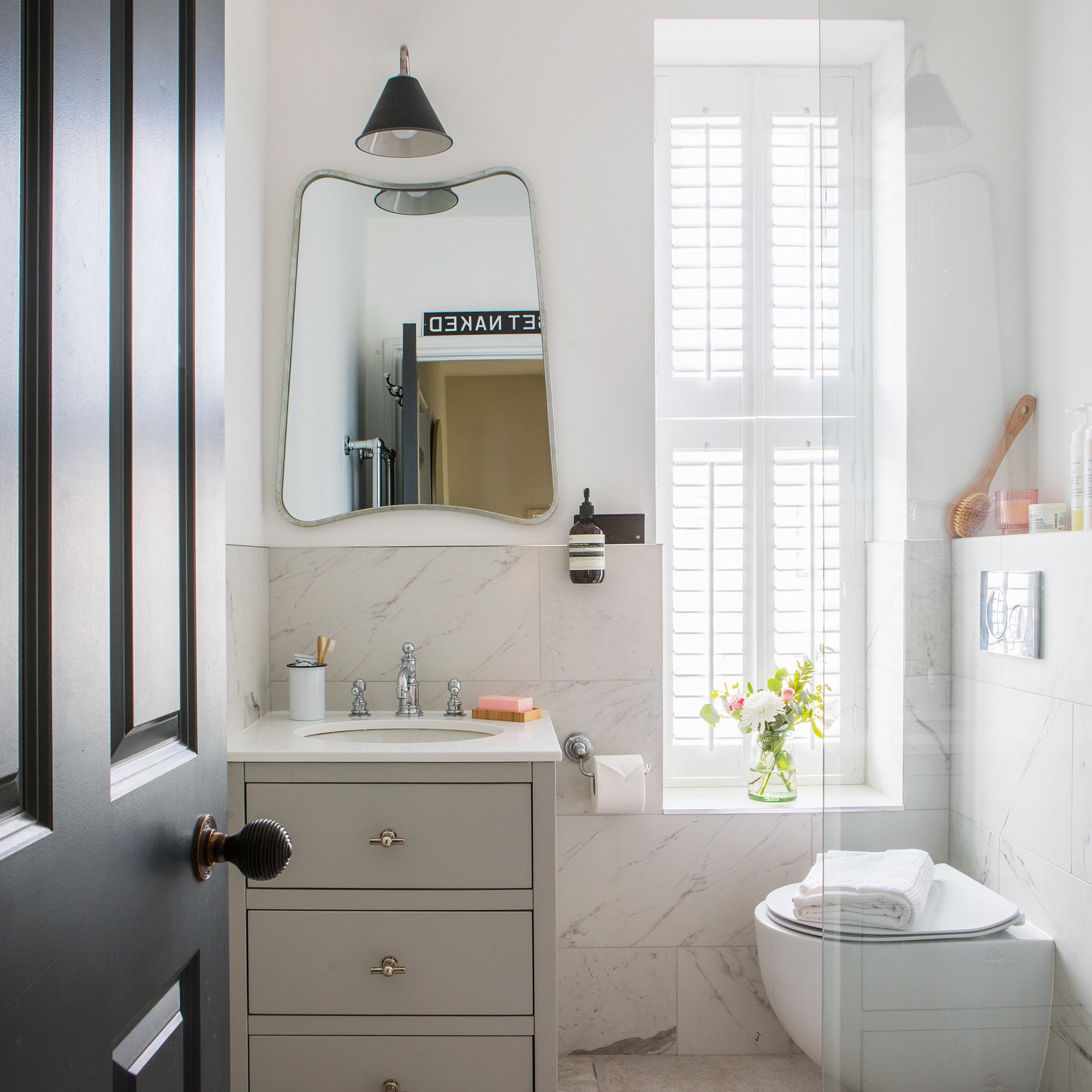 Small white bathroom with marble tiles and a grey sink vanity