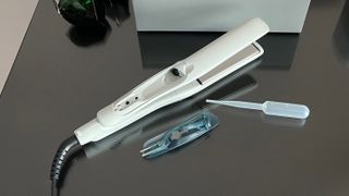 The Remington Hydraluxe Pro Straightener S9001 with the water tank remove, and the pipette for filling it