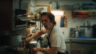 Jeremy Allen White freaks out while stirring a pot in the kitchen in The Bear.