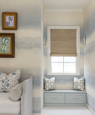 room with pale blue wallcovering and window seat and sofa