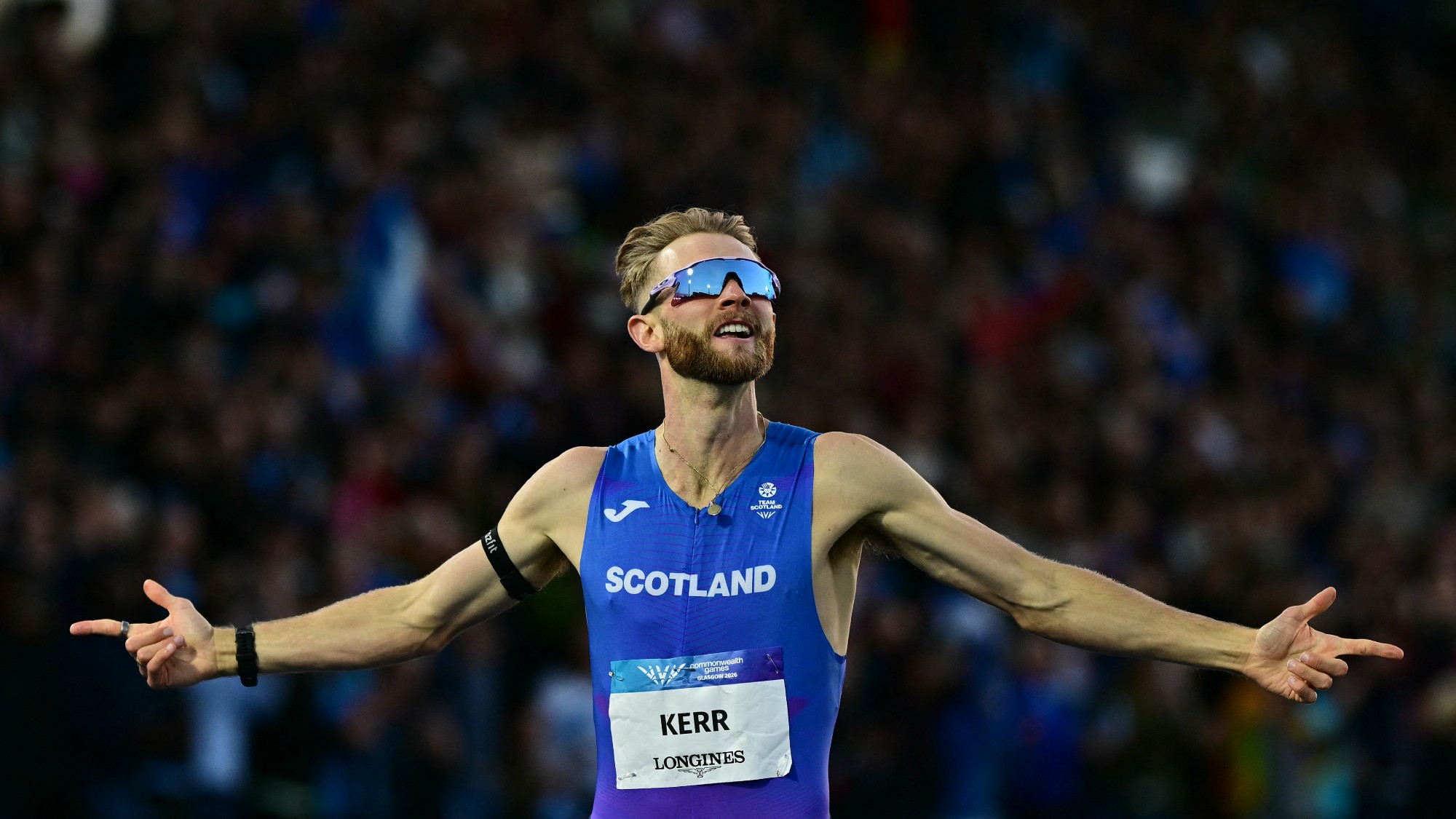 Scotland's Josh Kerr celebrates as he crosses the finish line to win the men's one-mile final at the Commonwealth Games in Glasgow 