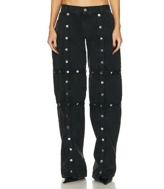 studded pants by the attico worn by a model in front of a plain backdrop