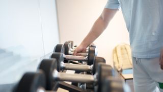 Man lifting dumbbell out of rack in a gym