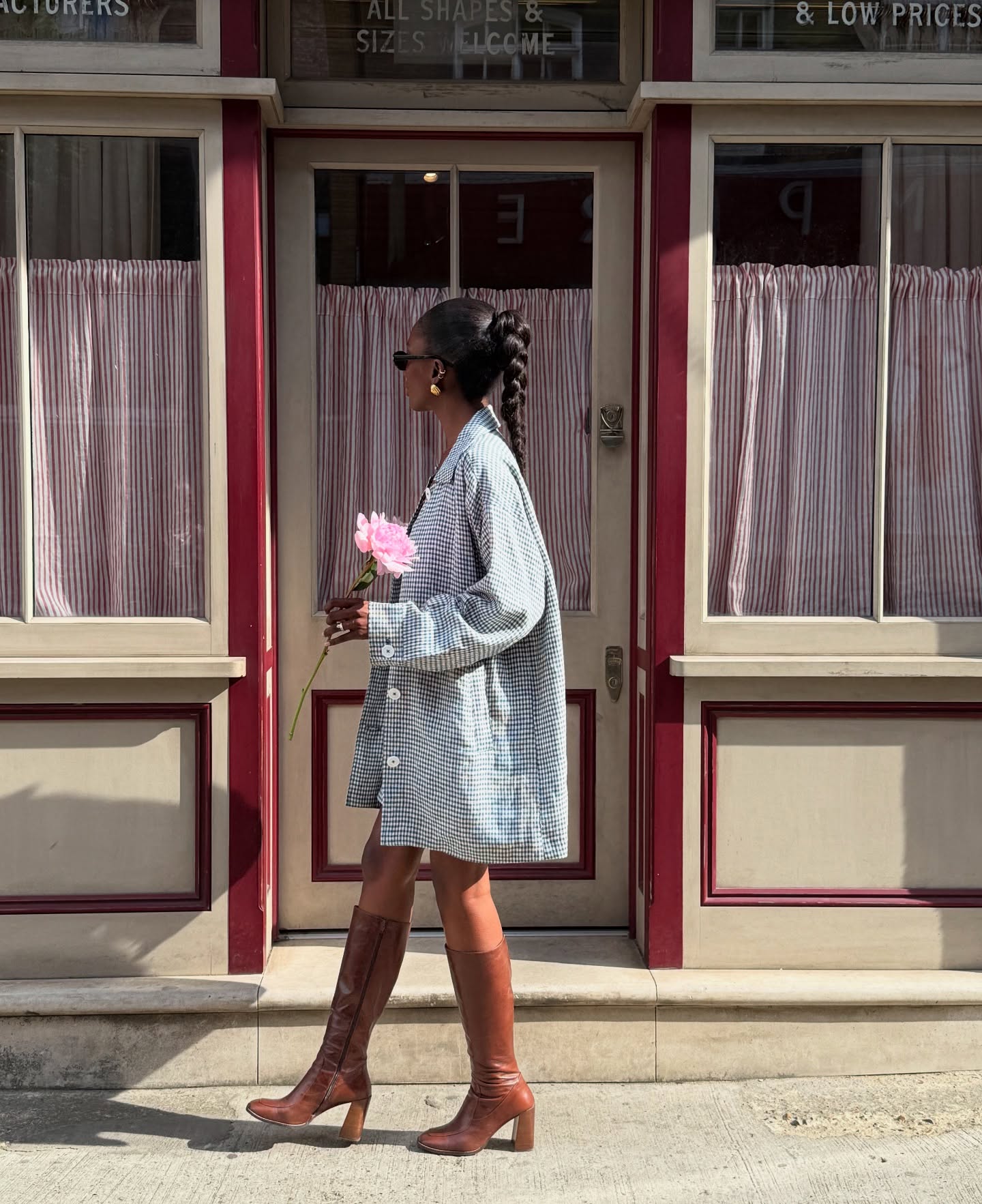 An image of @_livmadeline wearing a gingham spring jacket with a dress and brown boots.