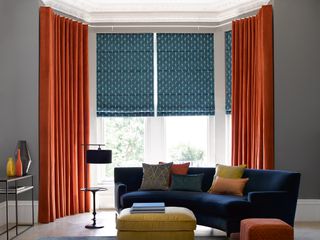 A combination of blinds and curtains in a bay window