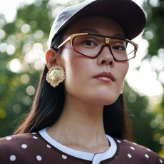 woman with a baseball hat, sunglasses and brown blush
