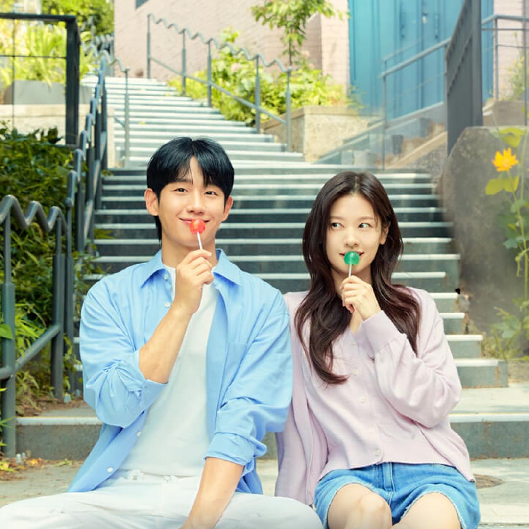 Jung Hae-in and Jung So-min, holding lollipops to their mouths while sittin...