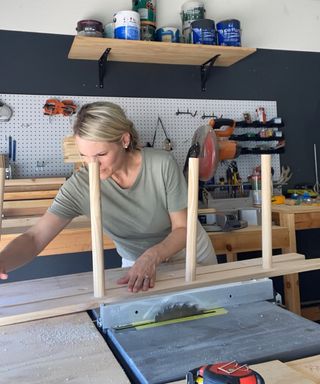 woman adding dowels to a piece of wood for a DIY loft bed ladder - Brooke Waite