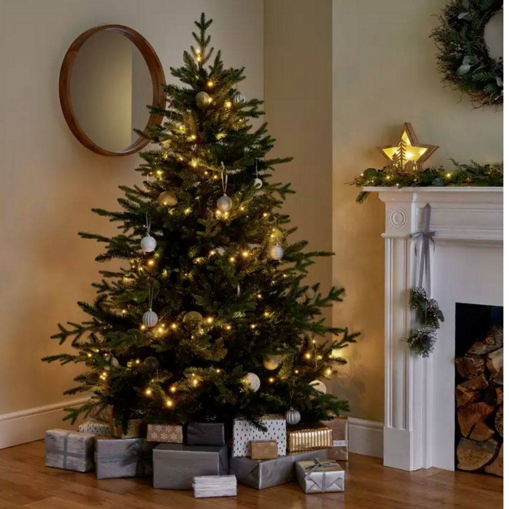 Habitat 6ft Mixed Tip Natural Look Christmas Tree inside living room beside fireplace with presents underneath
