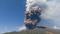 A photograph of Mount Etna erupting with a massive ash cloud on June 2, 2025. 