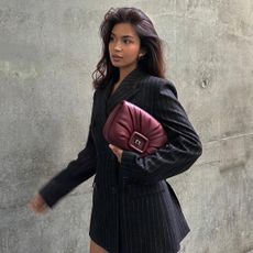 Woman in a blazer holding a red bag
