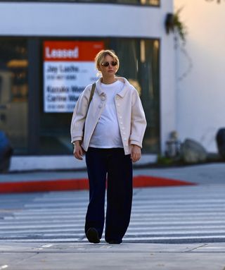 Jennifer Lawrence walks in Los Angeles wearing a pair of The Row's it boat shoes for 2025 with a pink jacket and a white t shirt