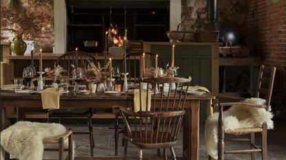 cozy dining room setting with candles and fur seat covers