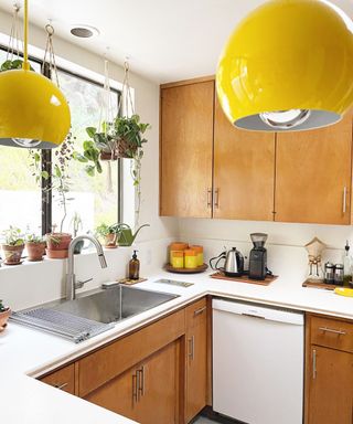 retro kitchen with wooden cabinets and yellow pendant lights