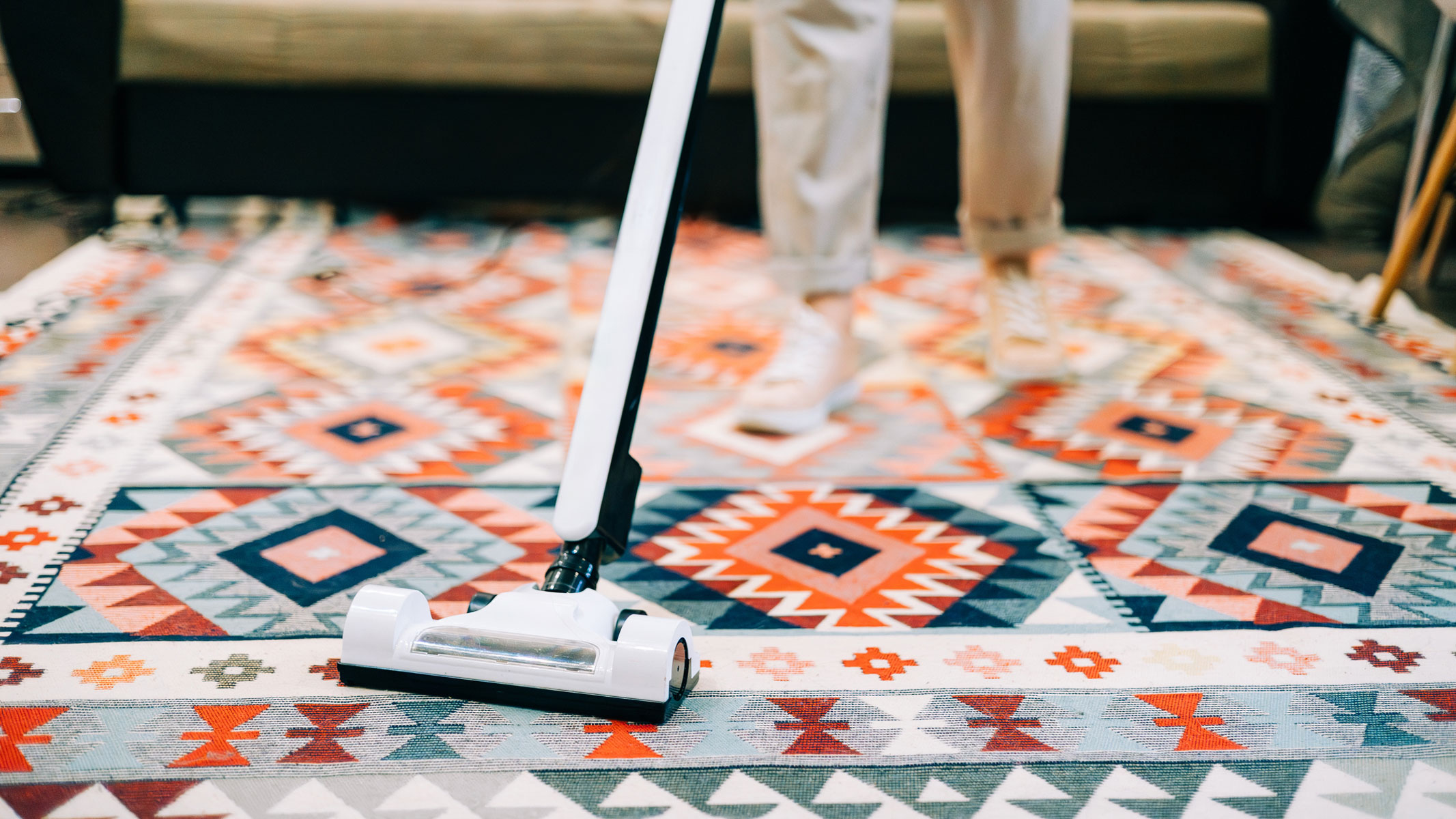 A close-up picture of someone hoovering the floor