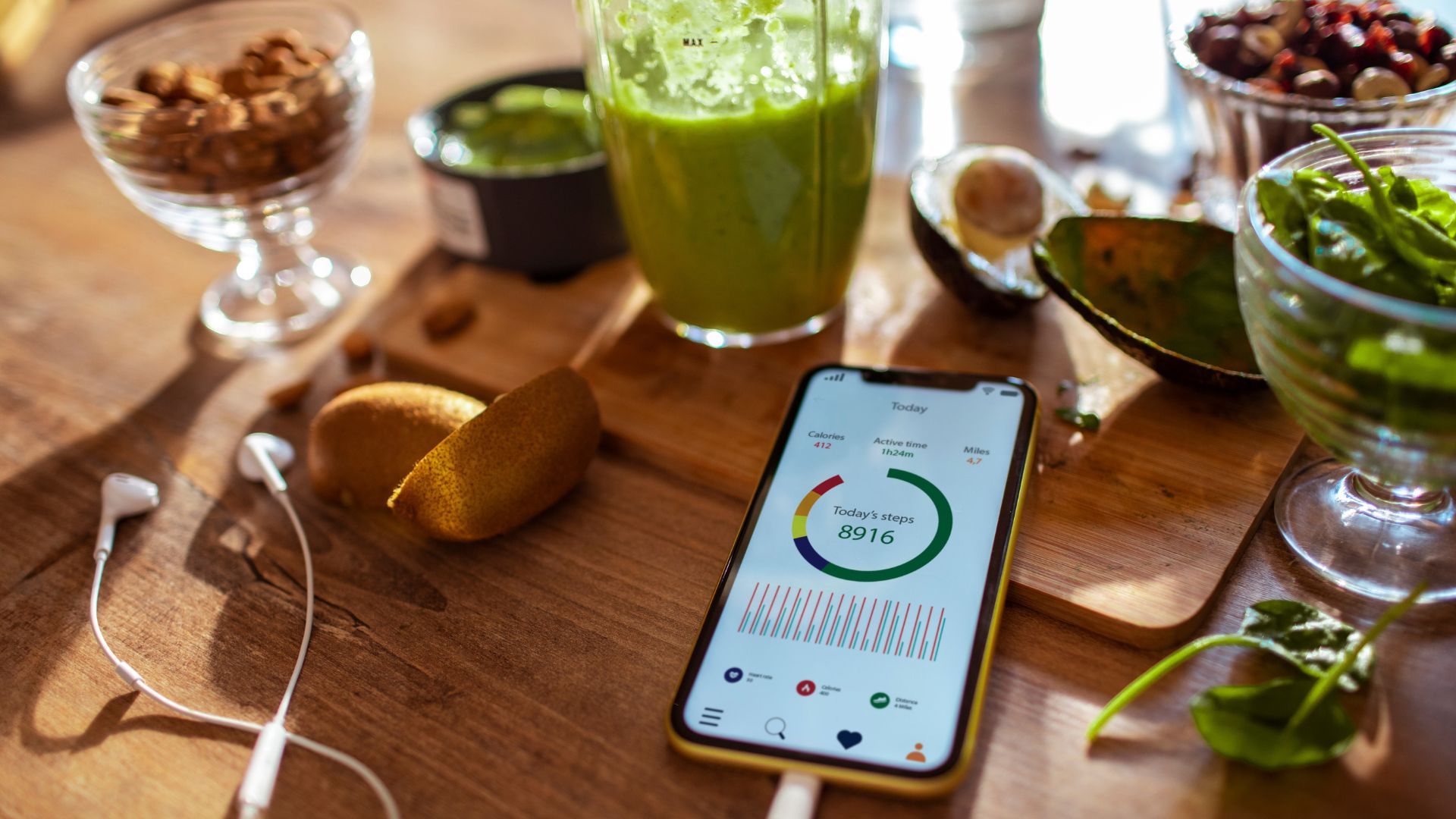 Phone with step count showing, next to green smoothie