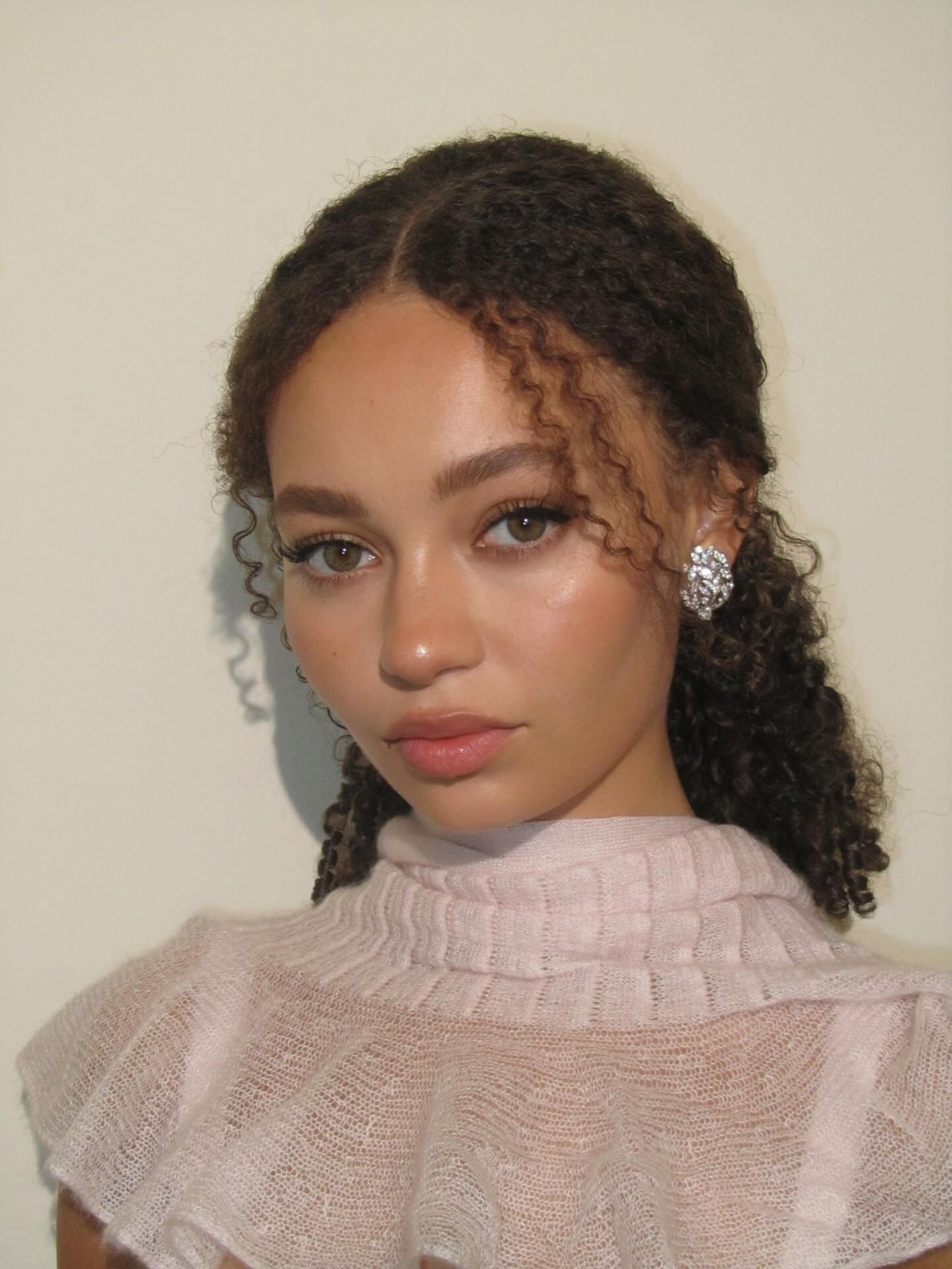 Nico Parker with half-up, half-down curly hairstyle