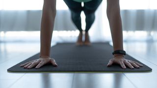 Hands and feet of a woman doing a plank pose