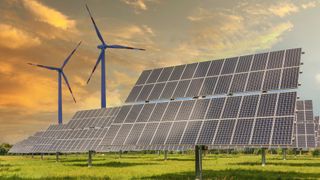 A wind farm and solar panels on a grassy hill