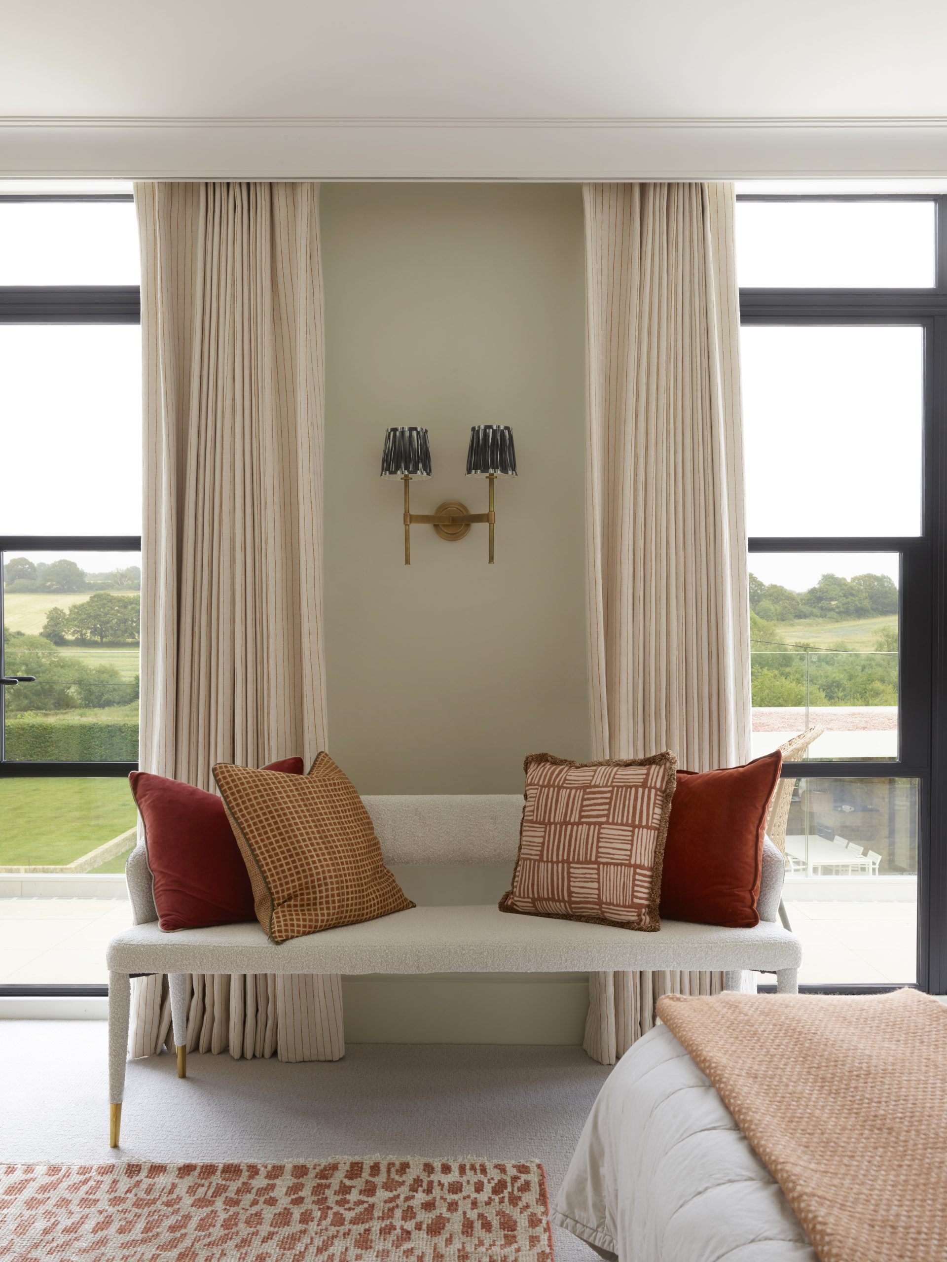 Light-filled bedroom with Crittall windows and a warm neutral color palette