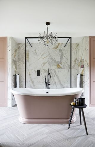 A bathroom with a chandelier above the bathtub