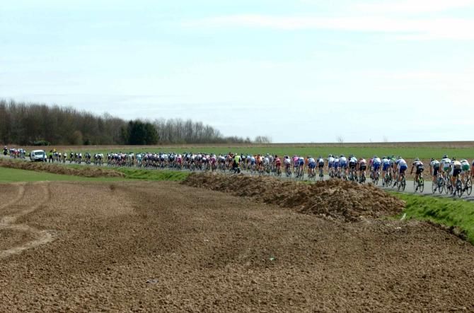 The bunch gets strung out on an open section at Fleche