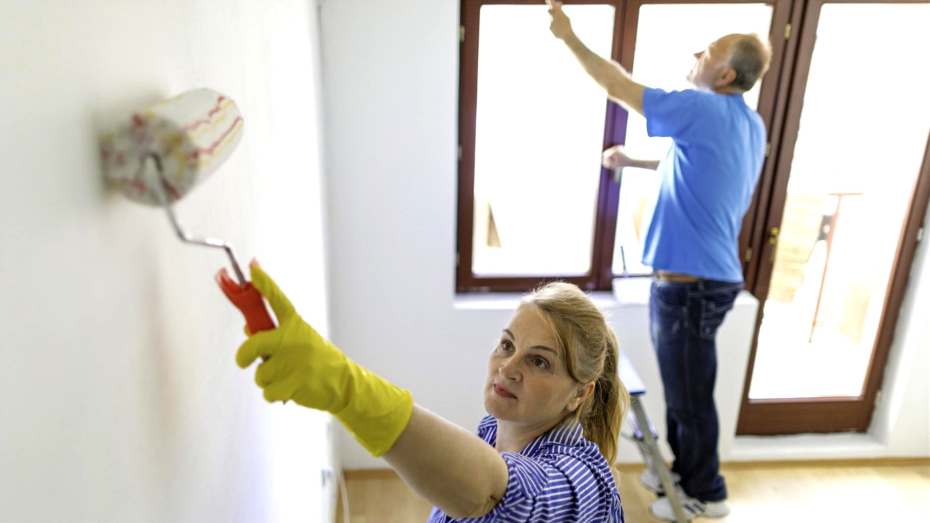 A couple freshening up the walls of their home 