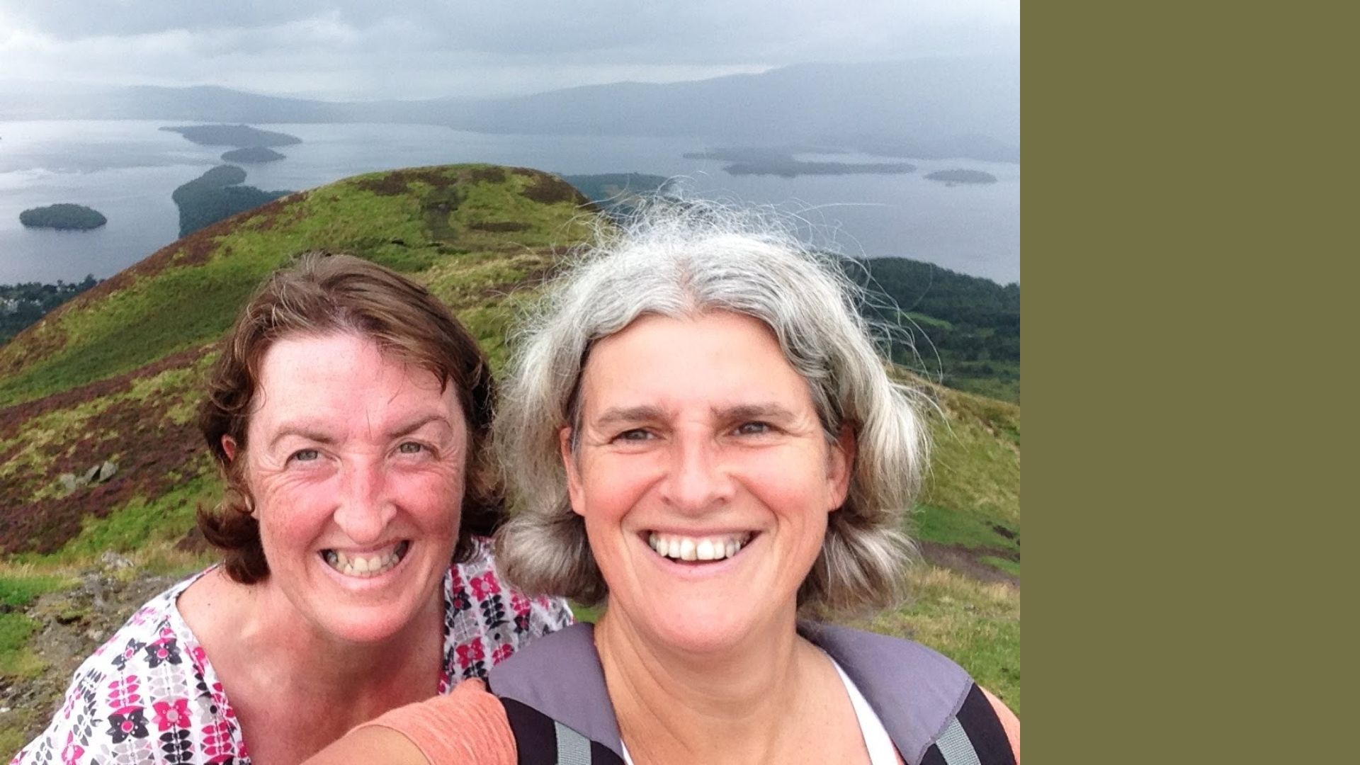 Tracey Howe standing on hilltop with wife Angela wearing hiking clothing and smiling