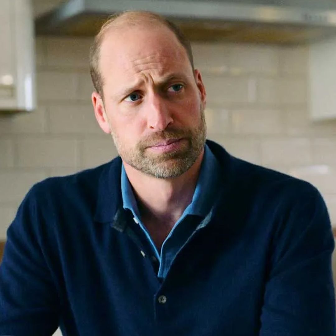 Prince William wearing a blue sweater sitting in a kitchen