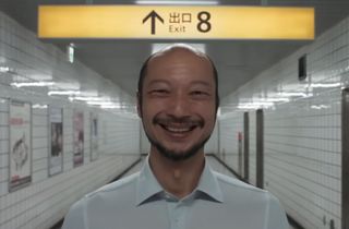 A smiling man in a subway station corridor
