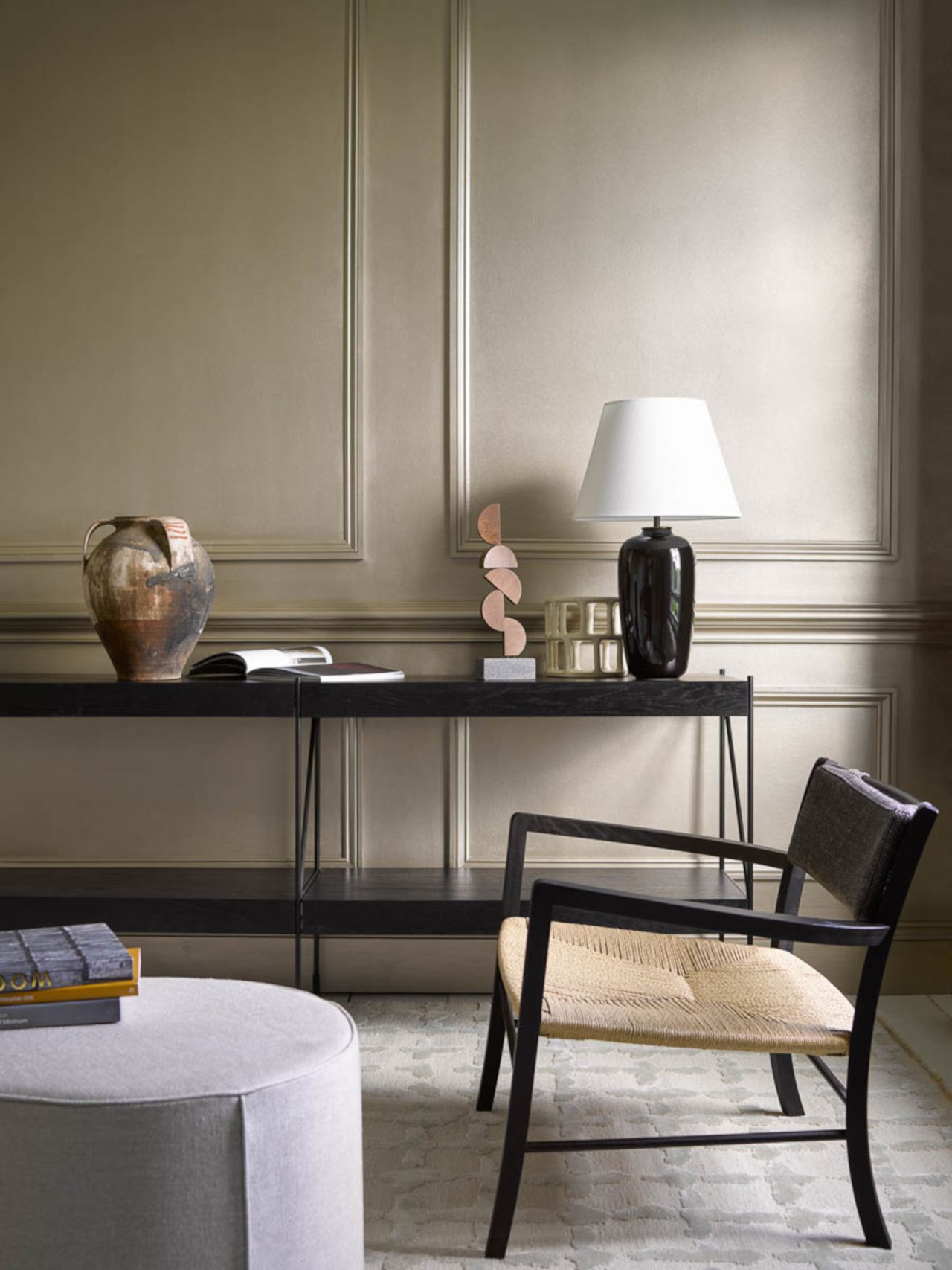 living room room black console, armchair, greay footstool, modern accessories, gray patterned rug