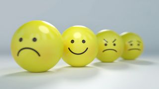 A group of emoji faces, one is frowning, another is smiling, another looks angry.