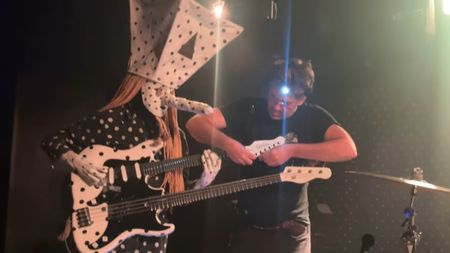 Angine de Poitrine's guitar tech restrings guitar while the band jams in New York, September 2026