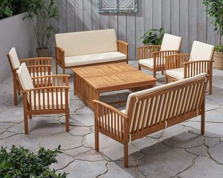 A teak wood conversational set with slatted wood frames and cream upholstered cushions