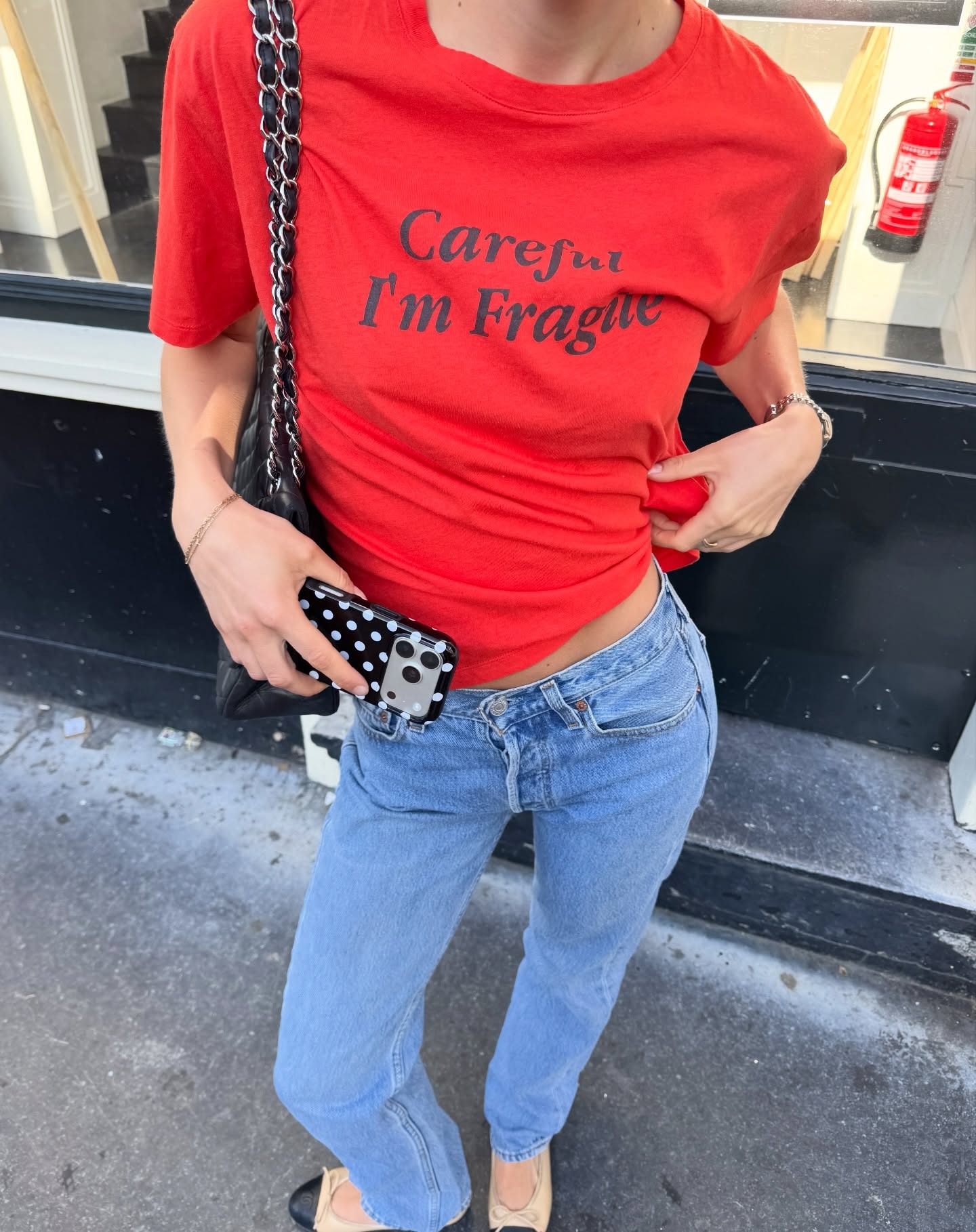 Woman in a red graphic tee and jeans