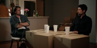 Jack and Brady sitting behind a makeshift table made from boxes with paper cups on top.