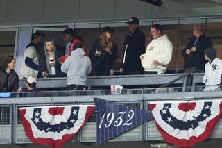 Taylor Swift and Travis Kelce in the box at the Yankees Guardians baseball game wearing black jackets and baseball caps