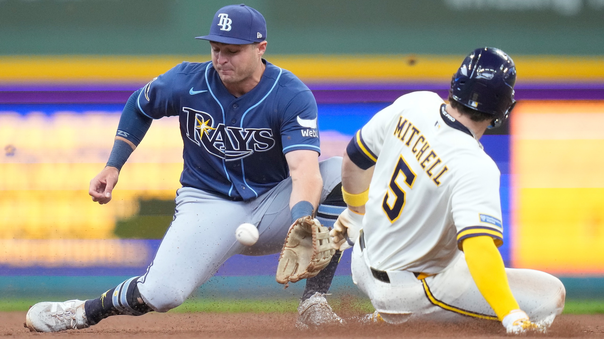 Garrett Mitchell of the Milwaukee Brewers steals second base as Tampa Bay Rays' Ben Williamson takes the throw in the second inning at American Family Field on April 01, 2026 in Milwaukee, Wisconsin