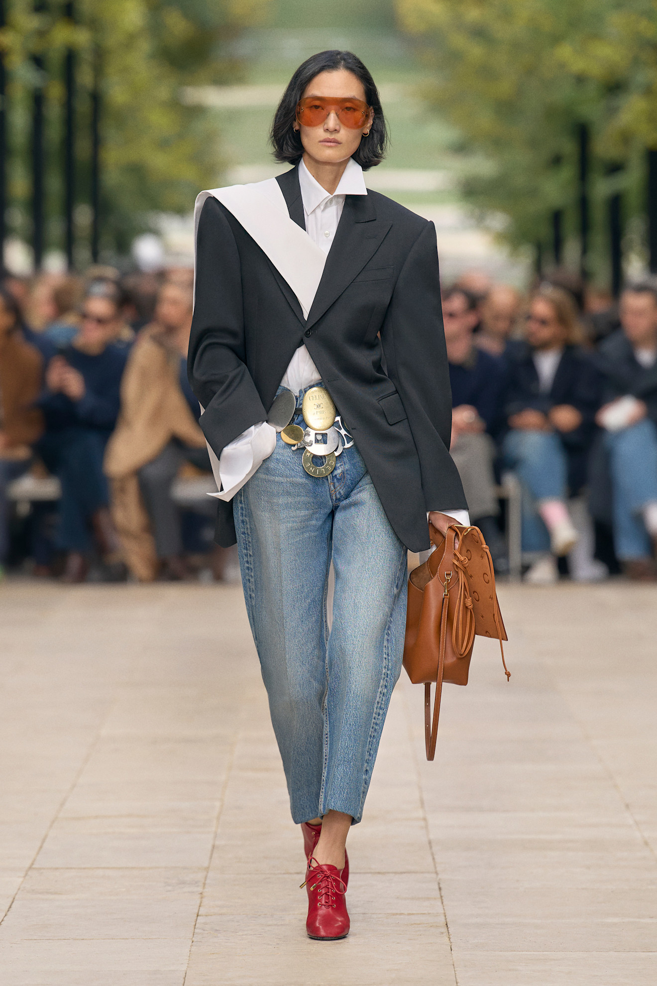 Model walks Celine PO S26 wearing coin belt jeans and blazer