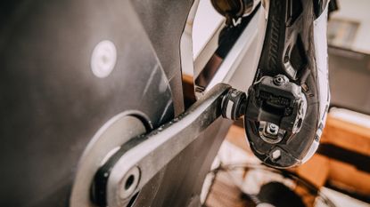 A rider clipped into power meter pedals on a smart bike