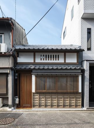 Terrace House near Demachiyanagi with a wood door, slat windows.
