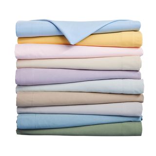 A stack of different colored bed sheets on a white background.