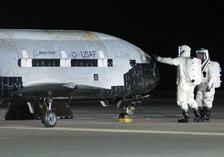 Technicians work on the the first X-37B space plane after a smooth landing on Dec.3, 2010 at Vandenberg Air Force Base in California. The same X-37B spacecraft launched back into space on Dec. 11, 2012, and could land at Vandenberg on Tuesday (Oct. 14, 20