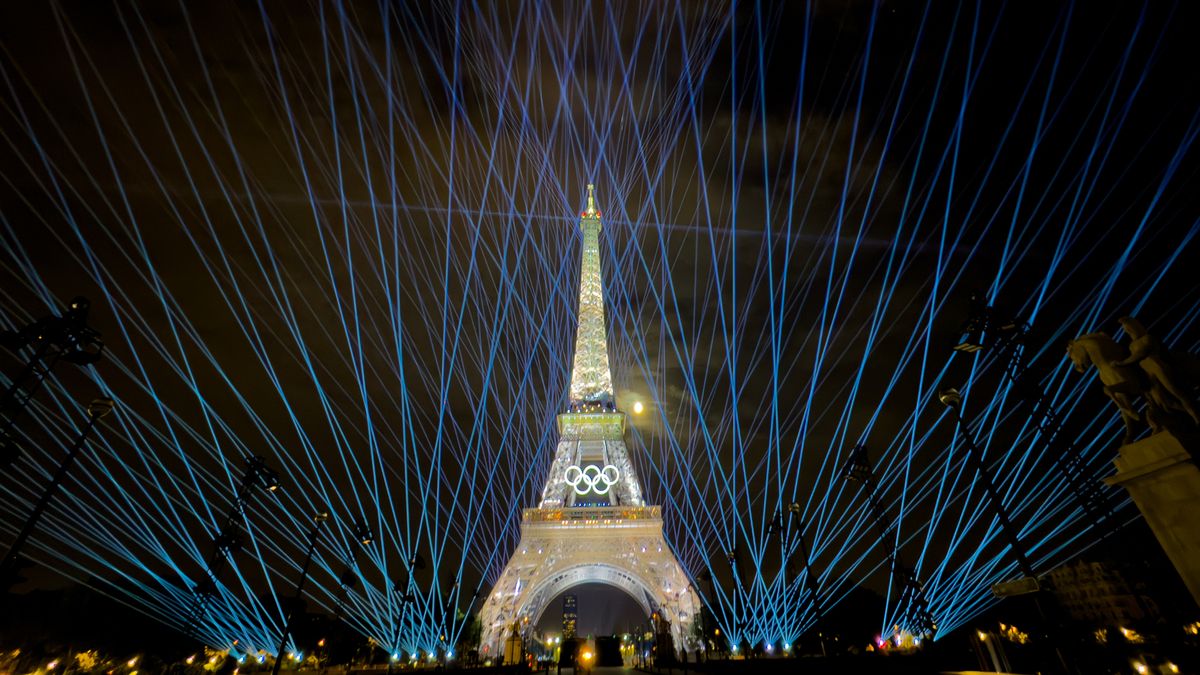 The Eiffel Tower lit up with light in a rehearsal run for the 2024 Paris Olympic opening ceremony