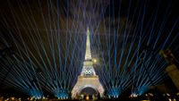 The Eiffel Tower lit up with light in a rehearsal run for the 2024 Paris Olympic opening ceremony