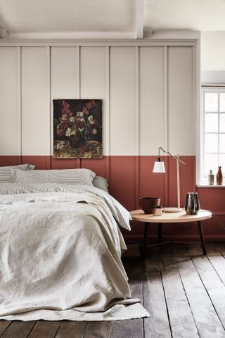 bedroom with colour blocked paint scheme and bed with original wooden flooring